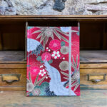 Llibreta. Tela japonesa. Estampat floral grues i motius platejats fons vermell.