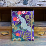 Llibreta.Tela japonesa. Estampat floral grues i motius platejats fons violeta.