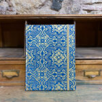 Notebook. Paper. Golden geometric pattern blue background.