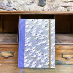 Notebook. Purple fabric spine and Chiyogami paper with golden motifs.