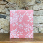 Álbum mediano. Tela de Damasco o de colchón. Estampado floral fondo rosa.
